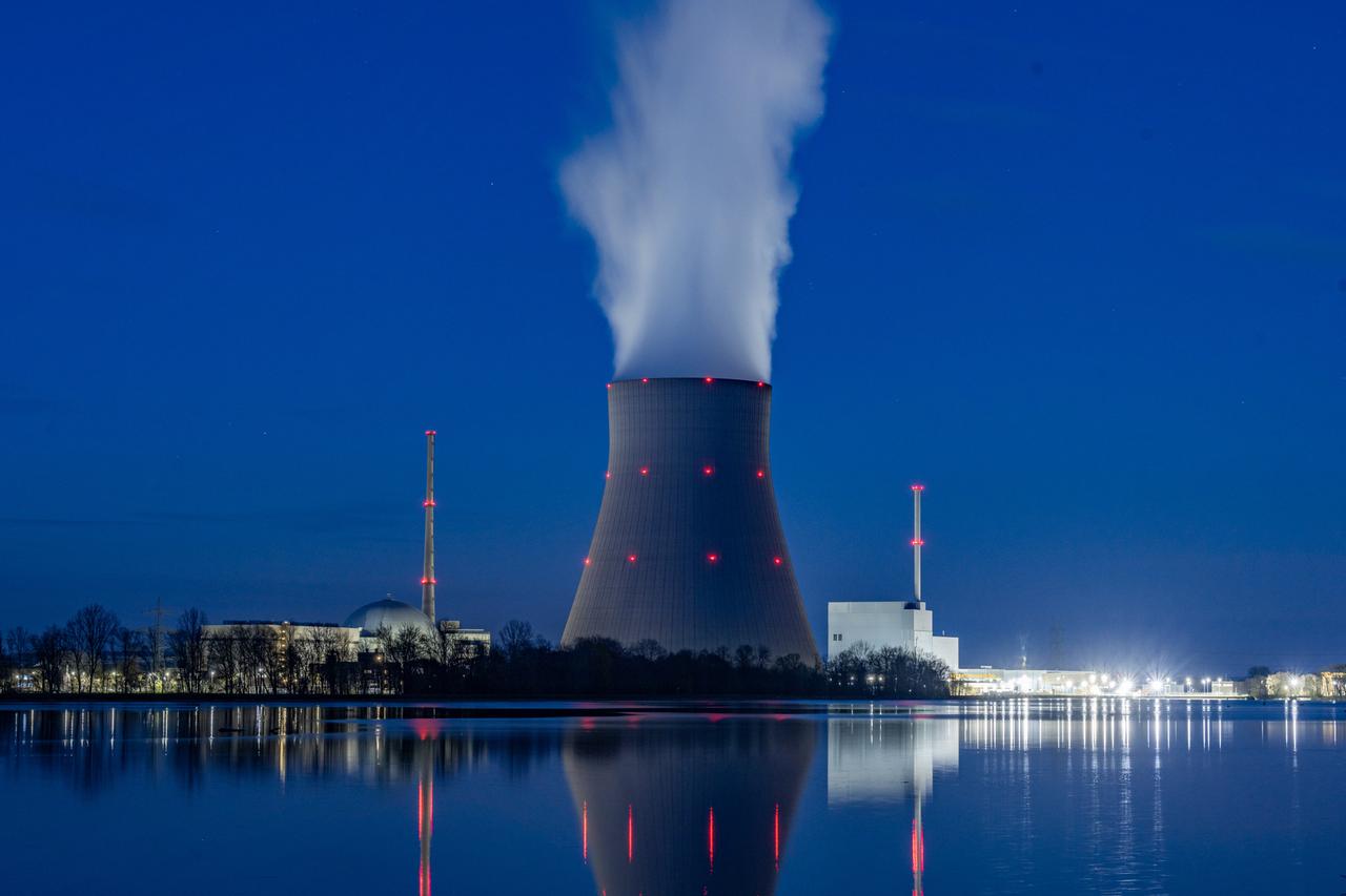 In der Abenddämmerung Wasserdampf steigt aus dem Kühltum des Kernkraftwerks Isar 2.