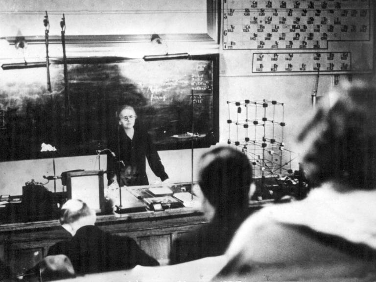 Das schwarz-weiße Bild zeigt Marie Curie bei einer Vorlesung im Radium-Institut in Paris im Jahr 1927