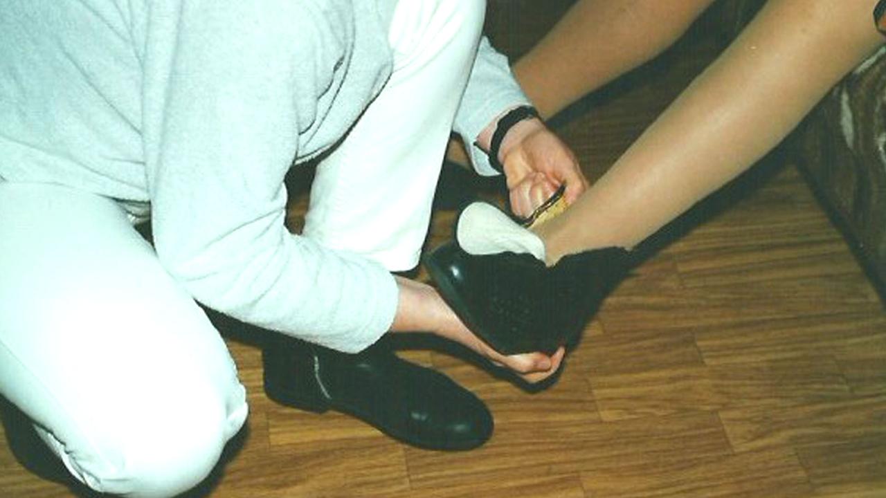 Krankenschwester Christiane Weyrosta zieht einer Patientin orthopädische Schuhe an, um 2000. Krankenschwester Christiane Weyrosta zieht einer Patientin orthopädische Schuhe an, um 2000.