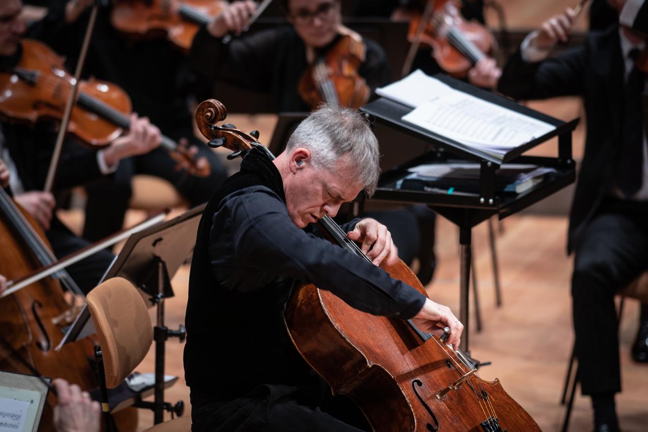Alban Gerhardt sitzt vertieft ins Cellospiel vor Musikern des Rundfunk-Sinfonierorchesters Berlin. Alban Gerhardt sitzt vertieft ins Cellospiel vor Musikern des Rundfunk-Sinfonierorchesters Berlin.