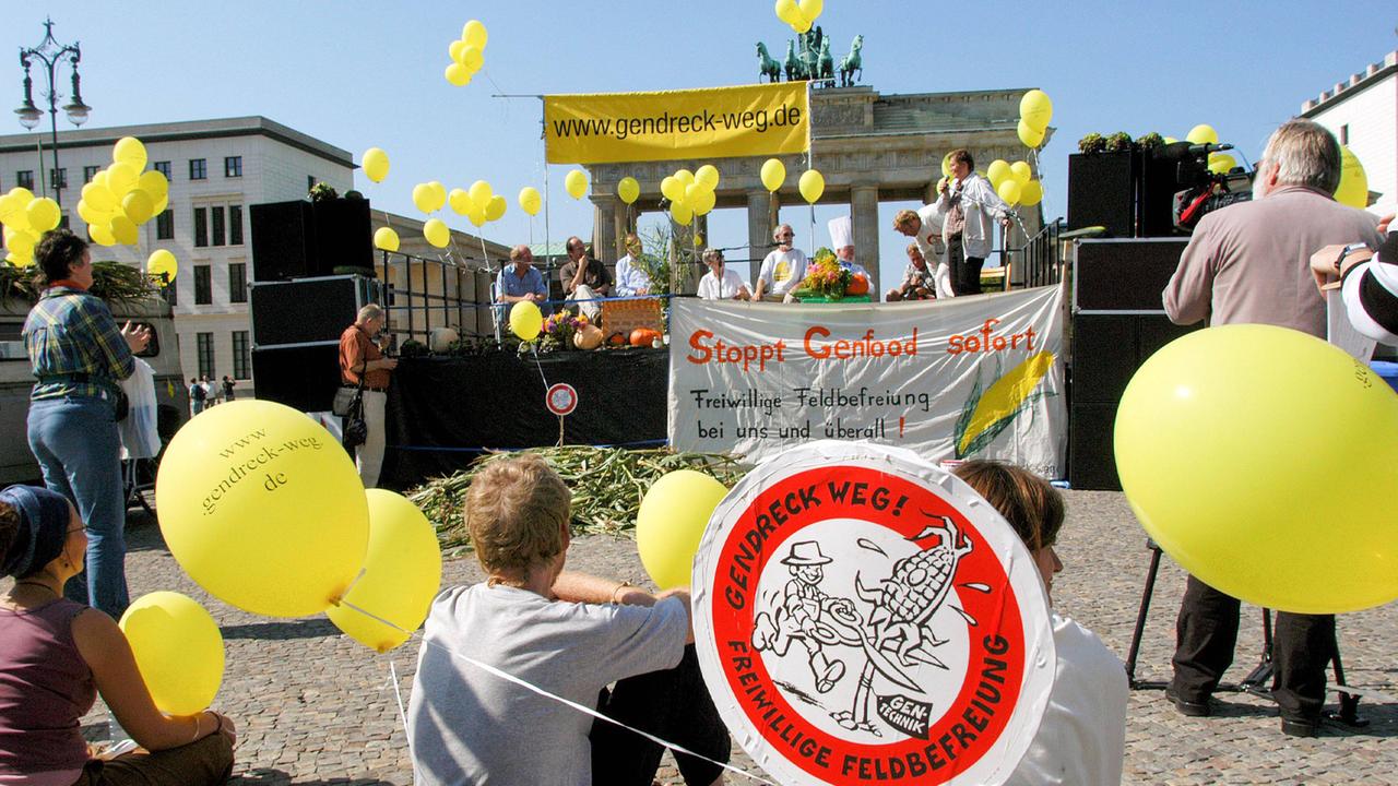 Demonstranten vor dem Brandenburger Tor in Berlin mit gelben Luftballons und Bannern und Schildern mit Aufschriften wie "Gendreck weg" und "Stoppt Genfood - sofort" (4. September 2005)