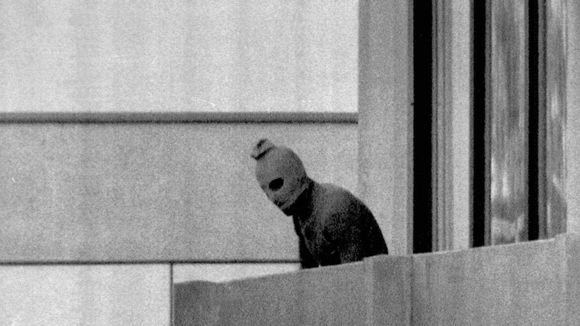 Einer der acht Terroristen, die Mitglieder des israelischen olympischen Teams in ihrer Unterkunft im olympischen Dorf in München als Geisel genommen haben, erscheint am 5. September 1972 auf dem Balkon des Gebäudes, in dem sich die Geiseln befinden. Einer der acht Terroristen, die Mitglieder des israelischen olympischen Teams in ihrer Unterkunft im olympischen Dorf in München als Geisel genommen haben, erscheint am 5. September 1972 auf dem Balkon des Gebäudes, in dem sich die Geiseln befinden.