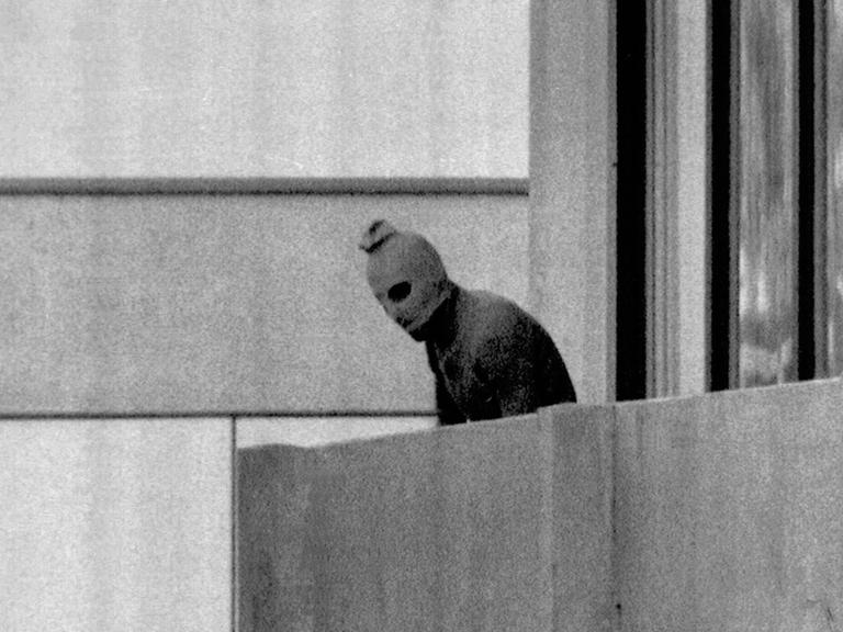 Einer der acht Terroristen, die Mitglieder des israelischen olympischen Teams in ihrer Unterkunft im olympischen Dorf in München als Geisel genommen haben, erscheint am 5. September 1972 auf dem Balkon des Gebäudes, in dem sich die Geiseln befinden. 