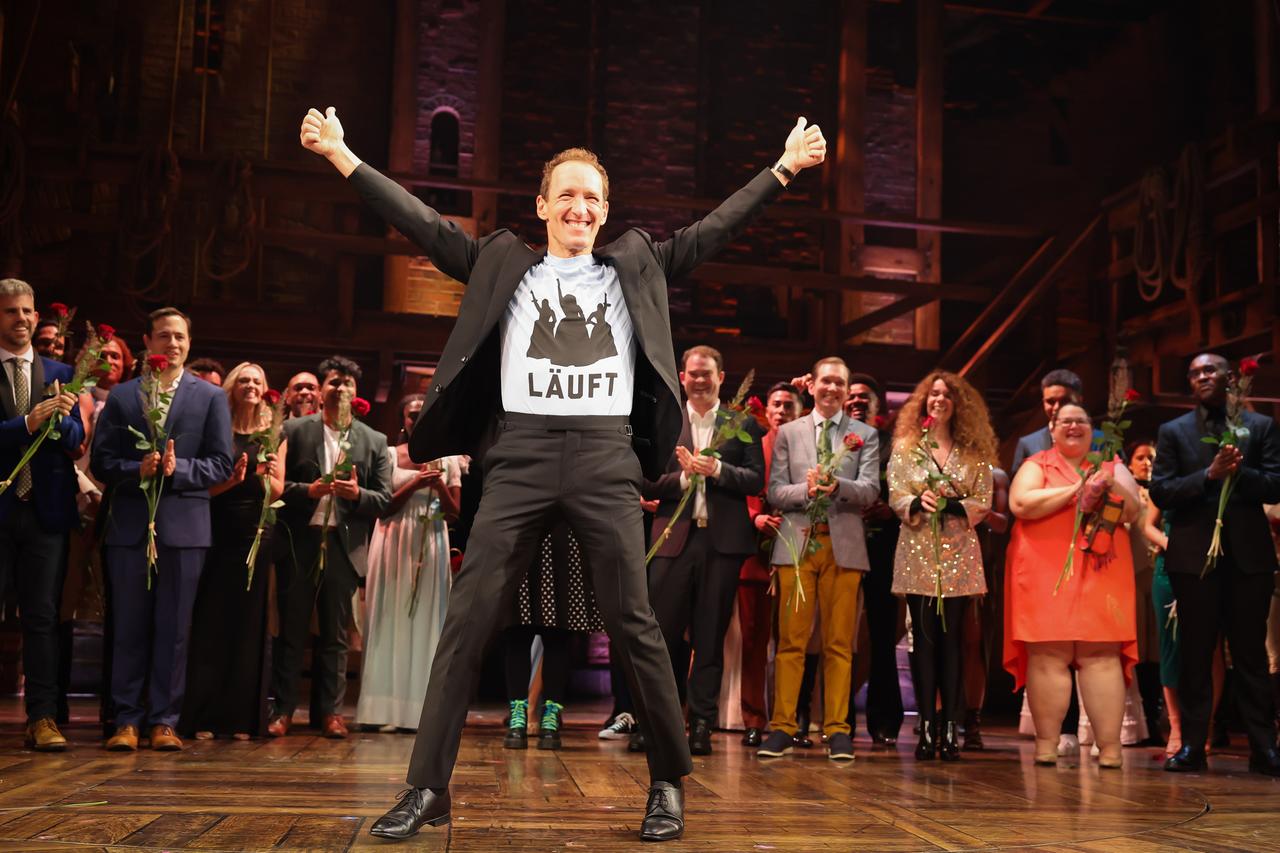 Jeffrey Seller, US-amerikanischer Theaterproduzent des Musicals, steht zusammen mit dem Ensemble beim Schlussapplaus nach der Premiere der deutschen Produktion des Broadway-Musicals "Hamilton" Hamburger im Operettenhaus auf der Bühne und hat die Hände mit "thumbs up" nach oben gestreckt. Auf seinem T-Shirt ist "Läuft" zu lesen. Jeffrey Seller, US-amerikanischer Theaterproduzent des Musicals, steht zusammen mit dem Ensemble beim Schlussapplaus nach der Premiere der deutschen Produktion des Broadway-Musicals "Hamilton" Hamburger im Operettenhaus auf der Bühne und hat die Hände mit "thumbs up" nach oben gestreckt. Auf seinem T-Shirt ist "Läuft" zu lesen.