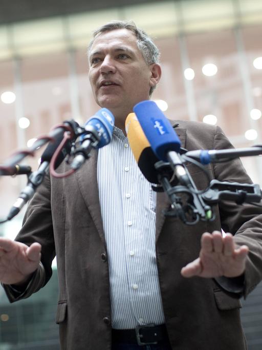 Jan van Aken spricht in Mikrofone