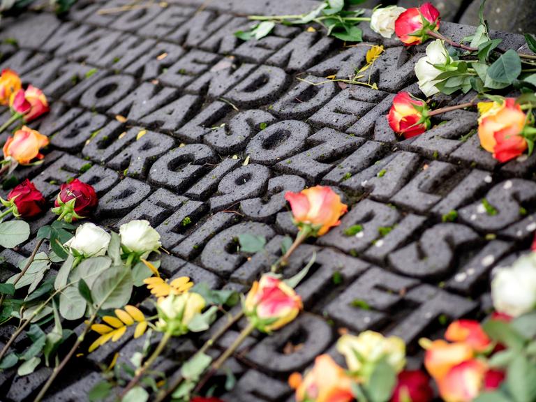 Zahlreiche Rosen liegen auf einer Gedenkstätte am ehemaligen Standort der Synagoge in Oldenburg.