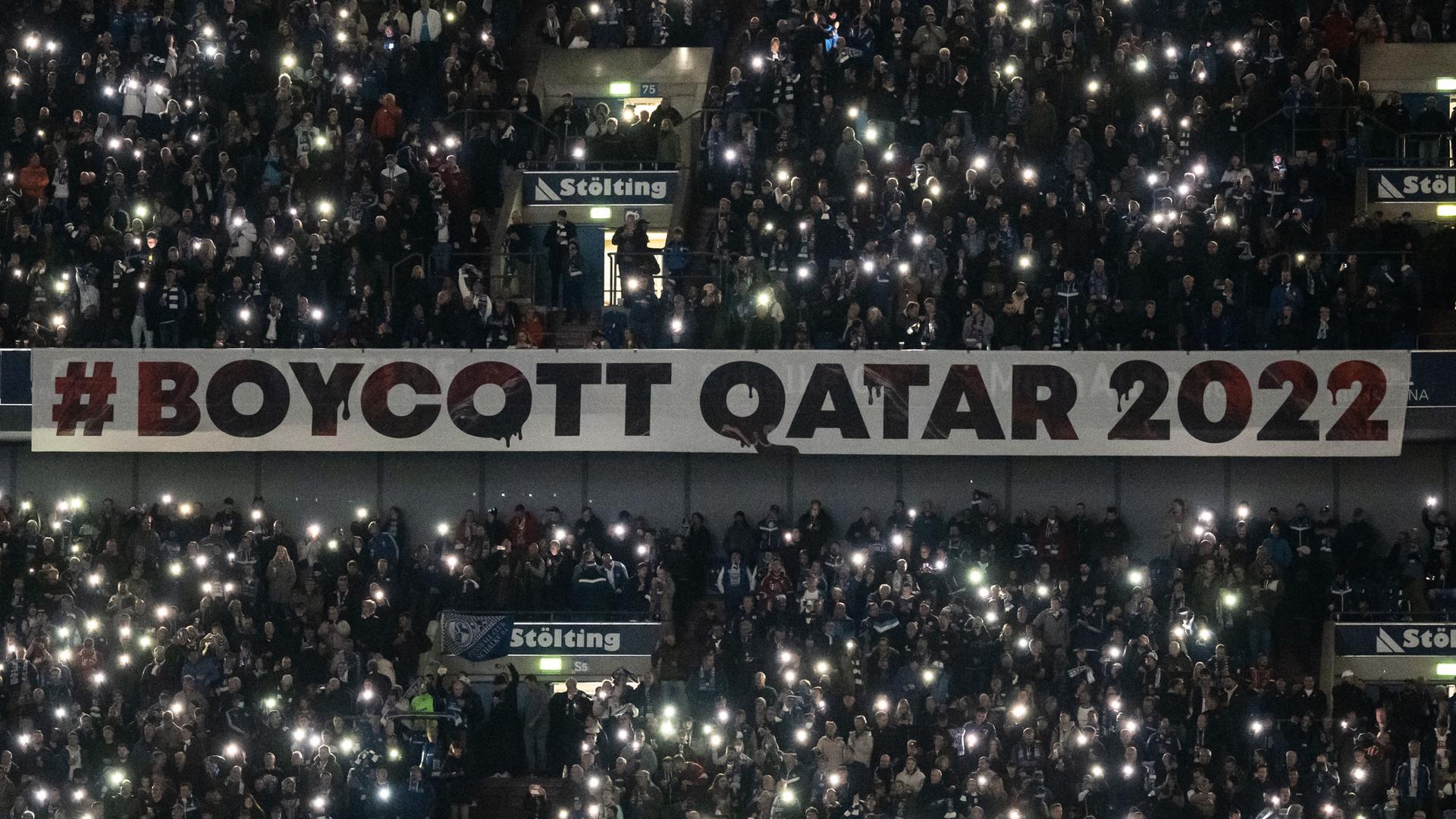Ein Banner mit der Aufschrift #Boycott Qatar 2022" im abgedunkelten Stadion