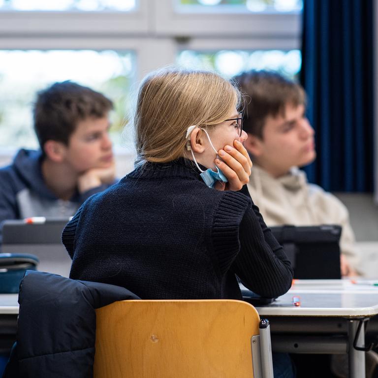 Schülerinnen und Schüler sitzen während des Unterrichts in einer Klasse.