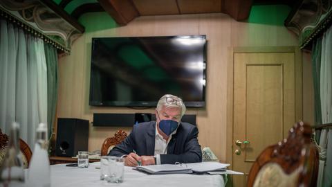 Bundespräsident Frank-Walter Steinmeier sitzt im Zug von Przemysl nach Kiew im Salonwagen und arbeitet in seinen Unterlagen. 