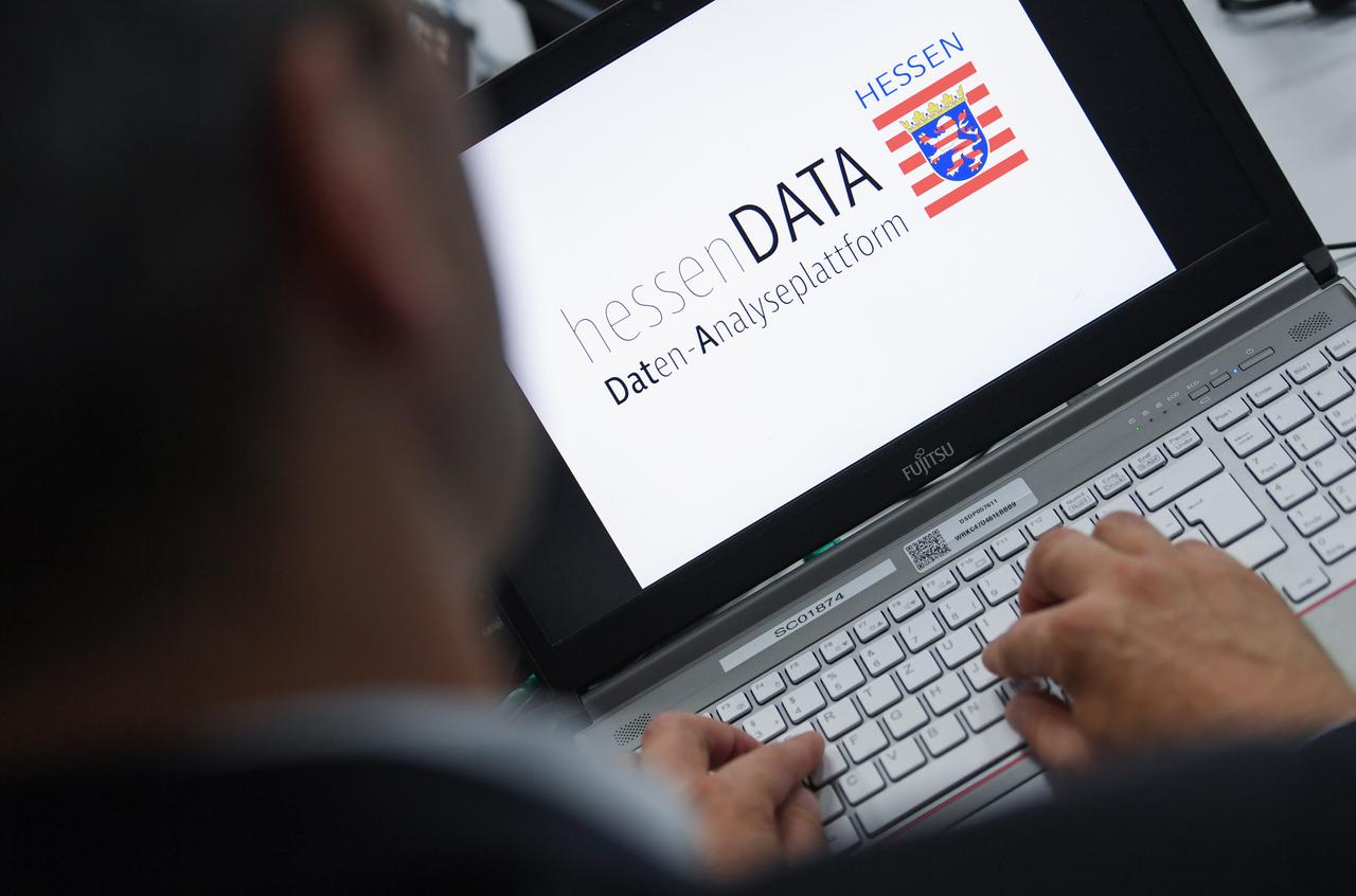 Ein Mann sitzt vor einem Laptop, auf dessen Bildschirm die Aufschrift "hessenDATA Daten-Analyseplattform" zu lesen ist.