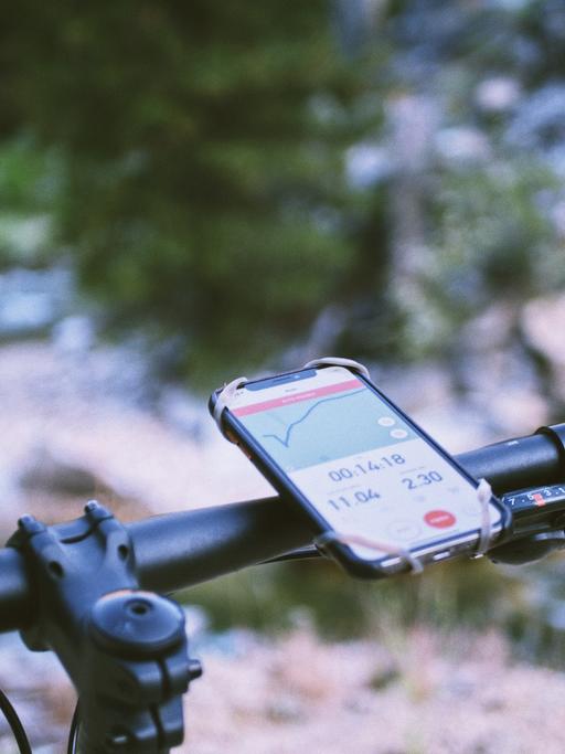 An einem Fahrradlenkrad hilft bei der Orientierung eine Handyapp.