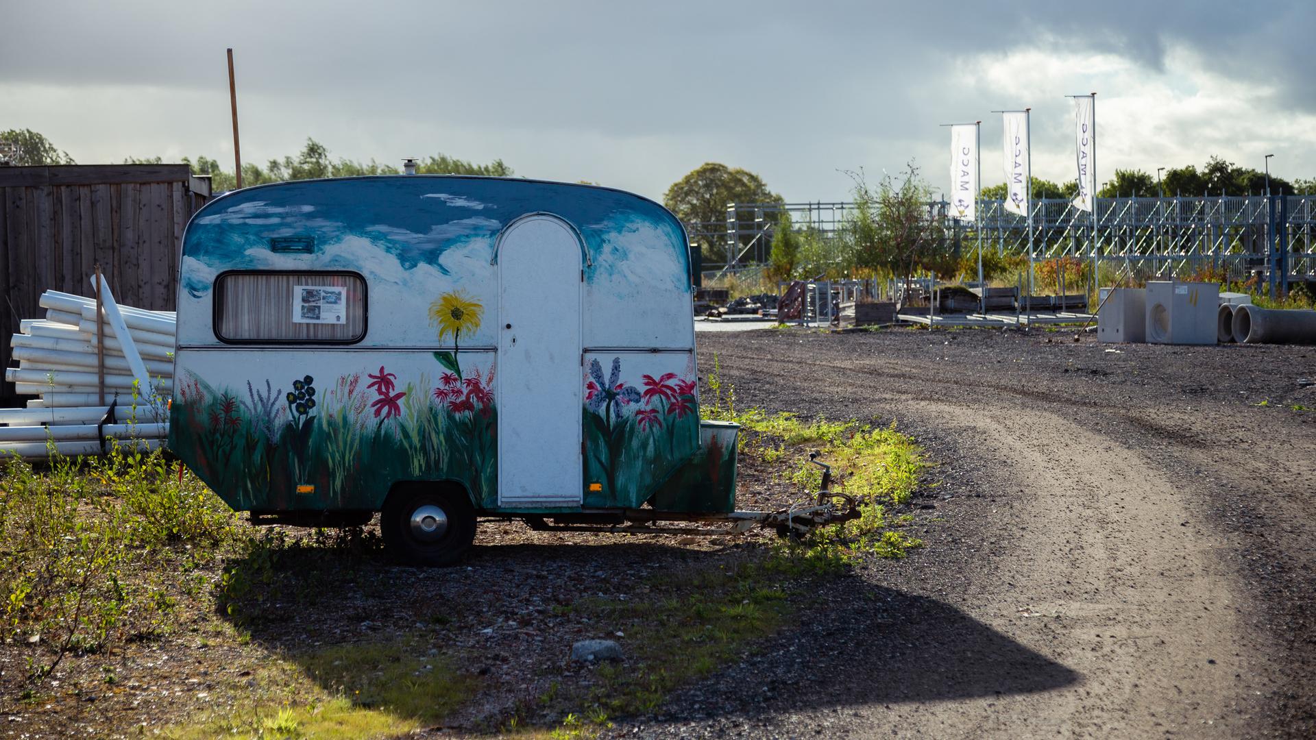 Ein kleiner Wohnwagen steht vor einem Hostel Ein kleiner Wohnwagen steht vor einem Hostel