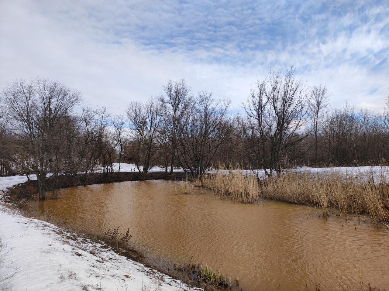 Winterlandschaft, darin ein Gewässer, dessen Wasser sich orangen gefärbt hat. Winterlandschaft, darin ein Gewässer, dessen Wasser sich orangen gefärbt hat.