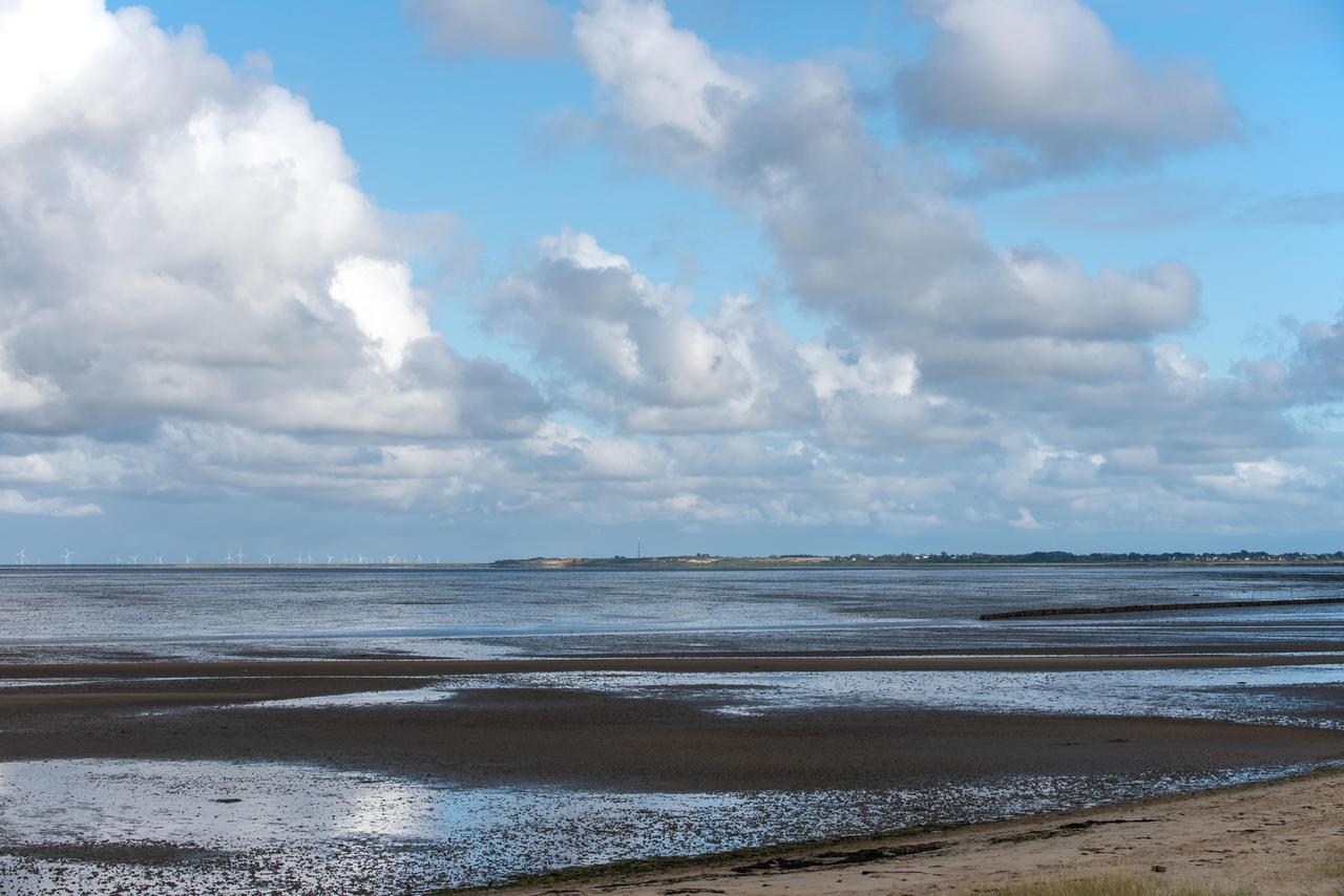 Ein Strand an der Nordseeküste mit einem wolkenreichen weiten Himmel. Ein Strand an der Nordseeküste mit einem wolkenreichen weiten Himmel.