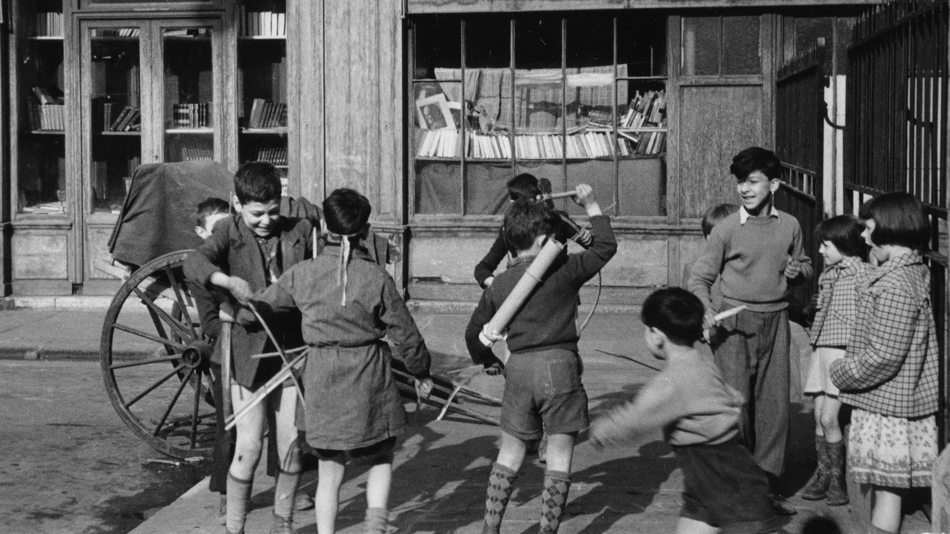 Auf seiner Suche nach Alfons Loeb trifft der Autor auf weitere deutsche Juden in Paris, die zumeist in Armut leben. Zu sehen: Jüdisches Viertel in Paris (um 1947): Kinder spielen vor einer Buchhandlung. Auf seiner Suche nach Alfons Loeb trifft der Autor auf weitere deutsche Juden in Paris, die zumeist in Armut leben. Zu sehen: Jüdisches Viertel in Paris (um 1947): Kinder spielen vor einer Buchhandlung.