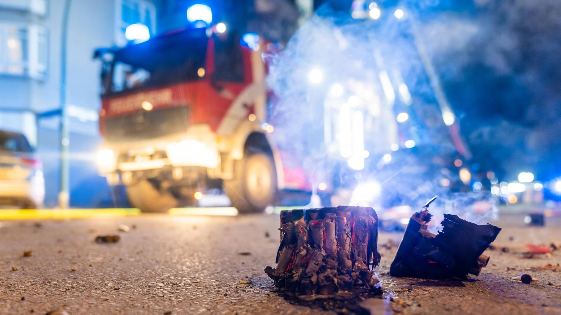 Reste von Silvesterböllern auf der Straße, im Hintergrund ein Einsatzfahrzeug der Feuerwehr. Reste von Silvesterböllern auf der Straße, im Hintergrund ein Einsatzfahrzeug der Feuerwehr.