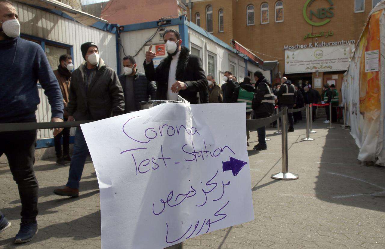 Vor einer Mosche sind Absperrungen und ein Schild mit der Aufschrift "Test-Station". Ordner sichern den Zutritt. Mehrere Gläubige sind mit Maske zu sehen.