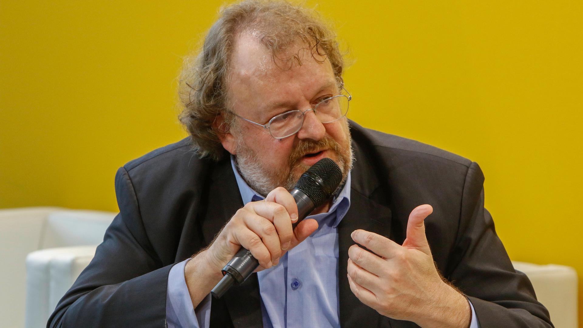 Der FAZ-Herausgeber Jürgen Kaube spricht 2019 auf der Frankfurter Buchmesse mit einem Mikrofon in der Hand.