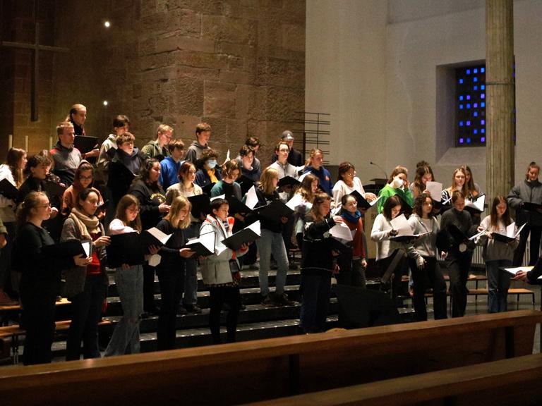 Die Sängerinnen und Sänger des Cantus Juvenum bei einer Probe in einer Kirche.