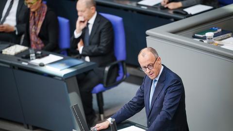 Friedrich Merz, CDU-Bundesvorsitzender und Unionsfraktionsvorsitzender, spricht im Bundestag. Hinter ihm verschwommen sitzt Bundeskanzler Scholz.