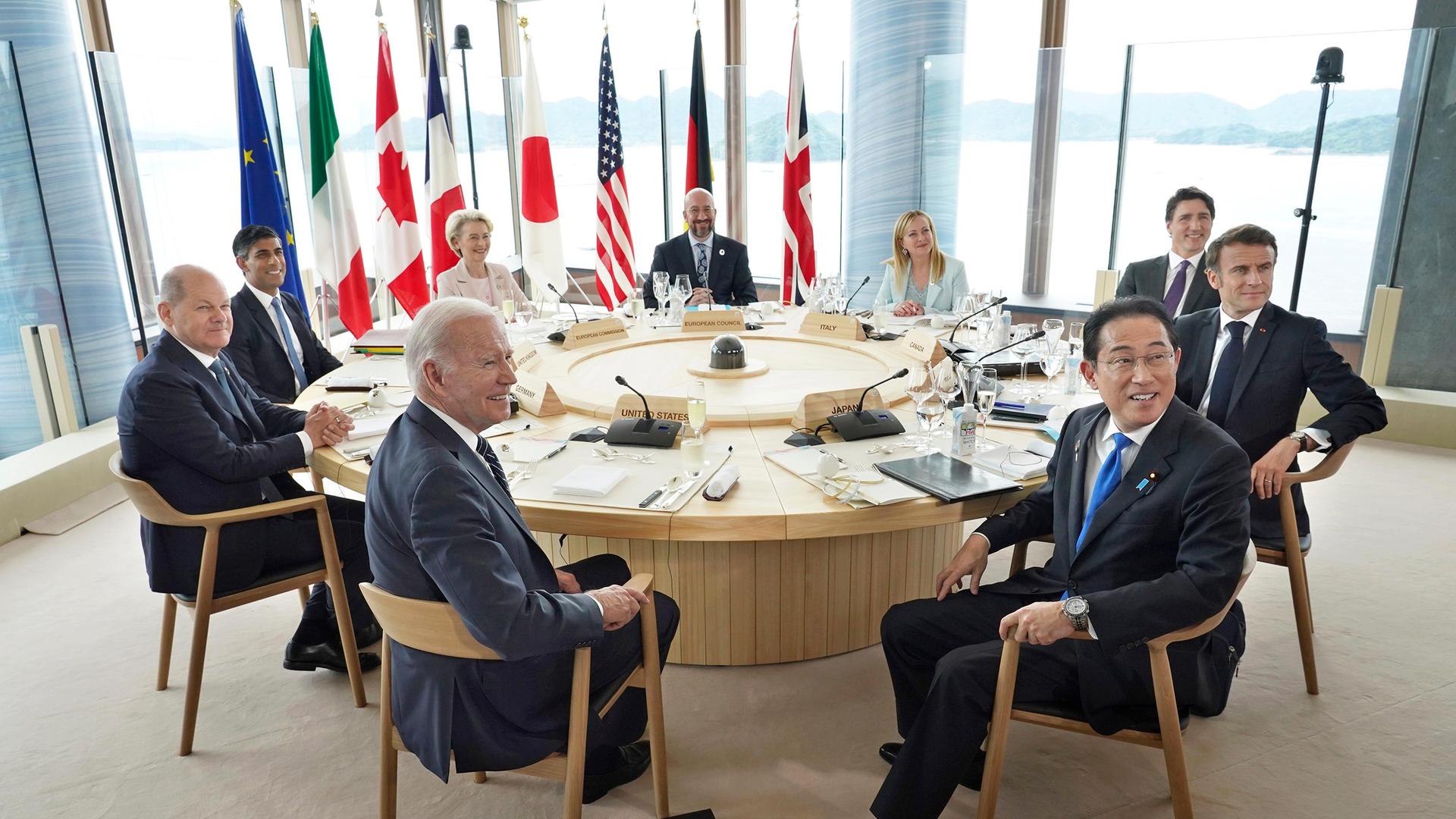 Die Staats- und Regierungschefs der G7-Staaten sitzen um einen runden Tisch. Hinter ihnen die Landesfahnen. Die Staats- und Regierungschefs der G7-Staaten sitzen um einen runden Tisch. Hinter ihnen die Landesfahnen.