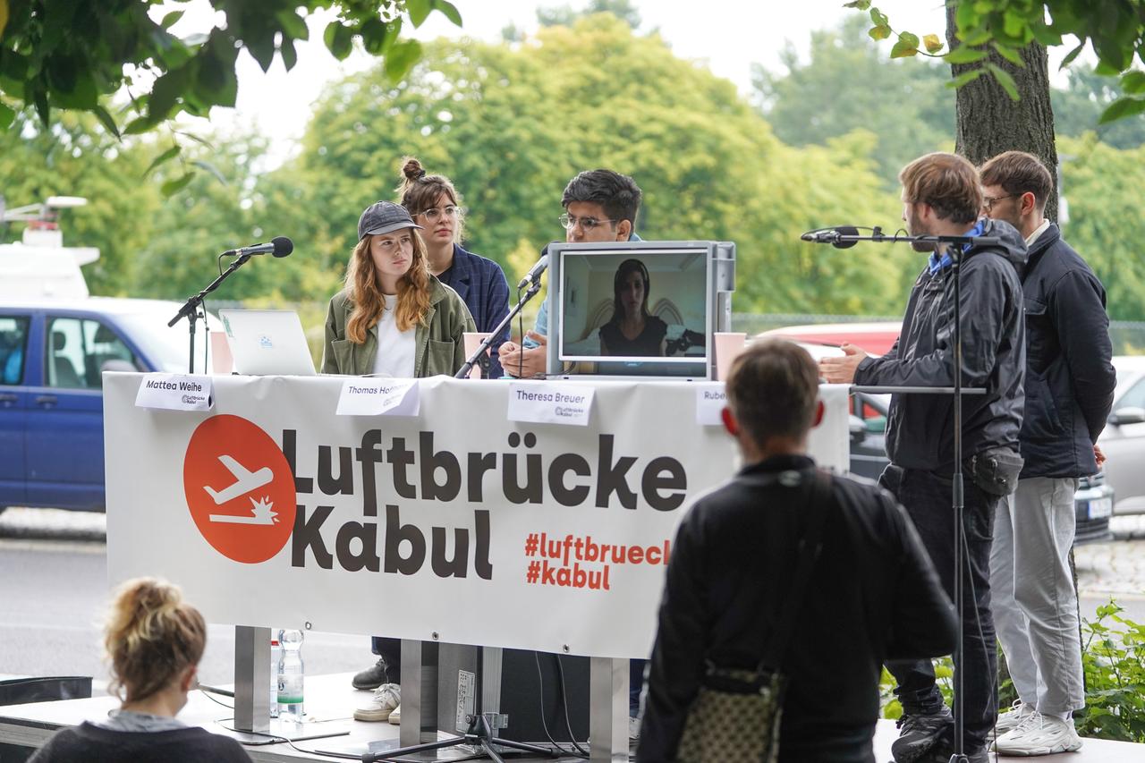 Pressekonferenz vom Aktionsbündnis "Luftbrücke Kabul" vor dem Bundesinnenministerium: Menschen stehen hinter einem Tisch, davor ein Banner mit der Aufschrift "Luftbrücke Kabul". Pressekonferenz vom Aktionsbündnis "Luftbrücke Kabul" vor dem Bundesinnenministerium: Menschen stehen hinter einem Tisch, davor ein Banner mit der Aufschrift "Luftbrücke Kabul".