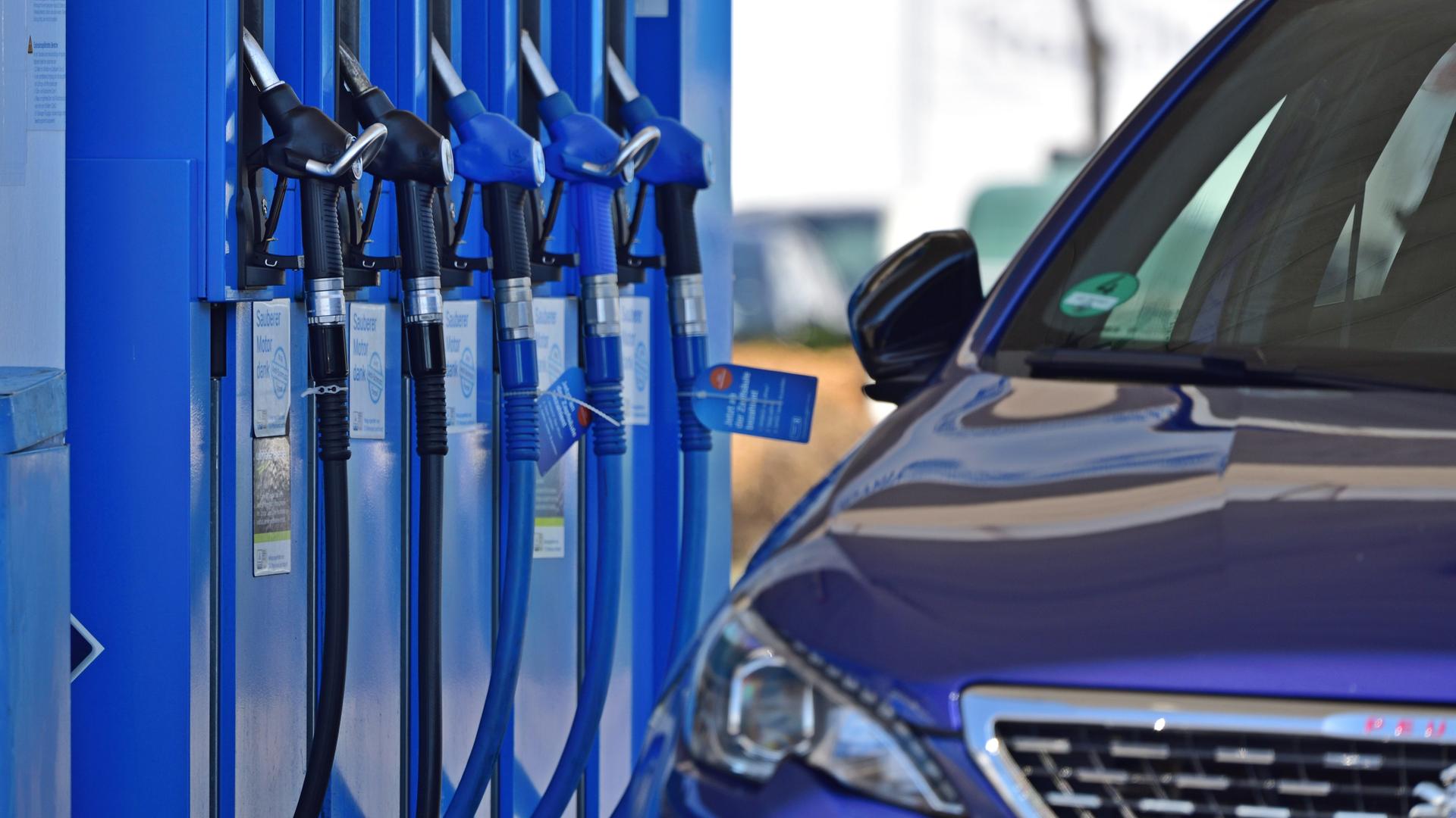 Ein Auto steht neben der Zapfsäule einer Tankstelle Ein Auto steht neben der Zapfsäule einer Tankstelle