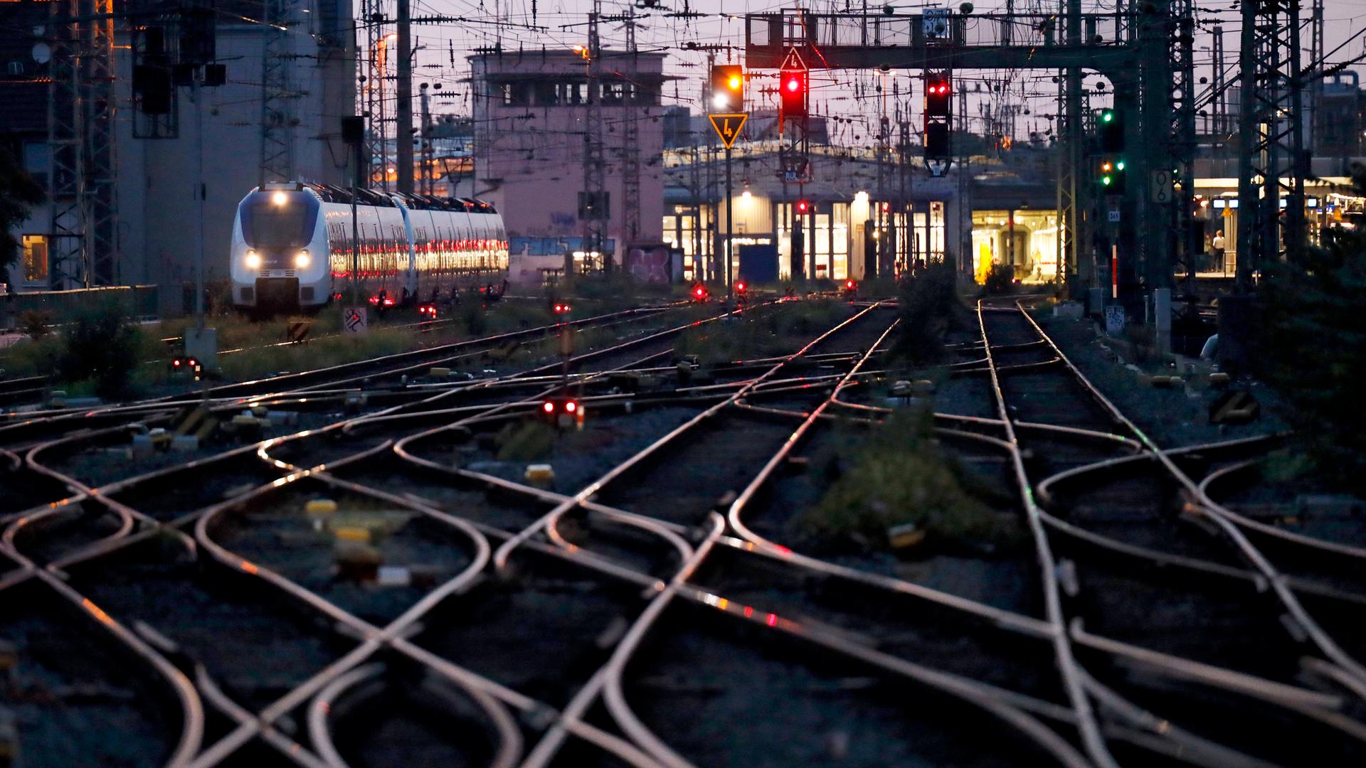 Verzweigte Eisenbahnschienen vor einem Bahnhof, links fährt ein ICE. Verzweigte Eisenbahnschienen vor einem Bahnhof, links fährt ein ICE.