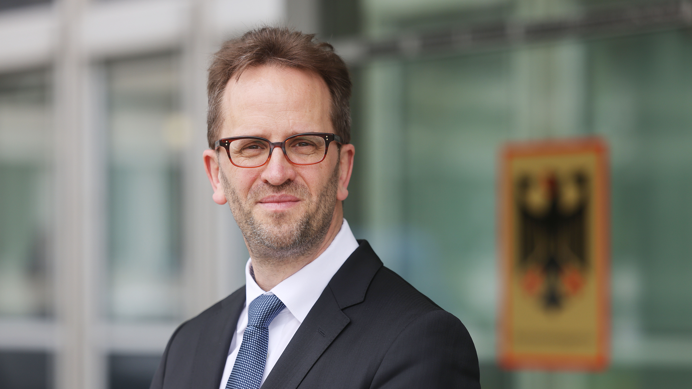 Klaus Müller, Präsident der Bundesnetzagentur, steht vor dem Haus der Bundesnetzagentur.