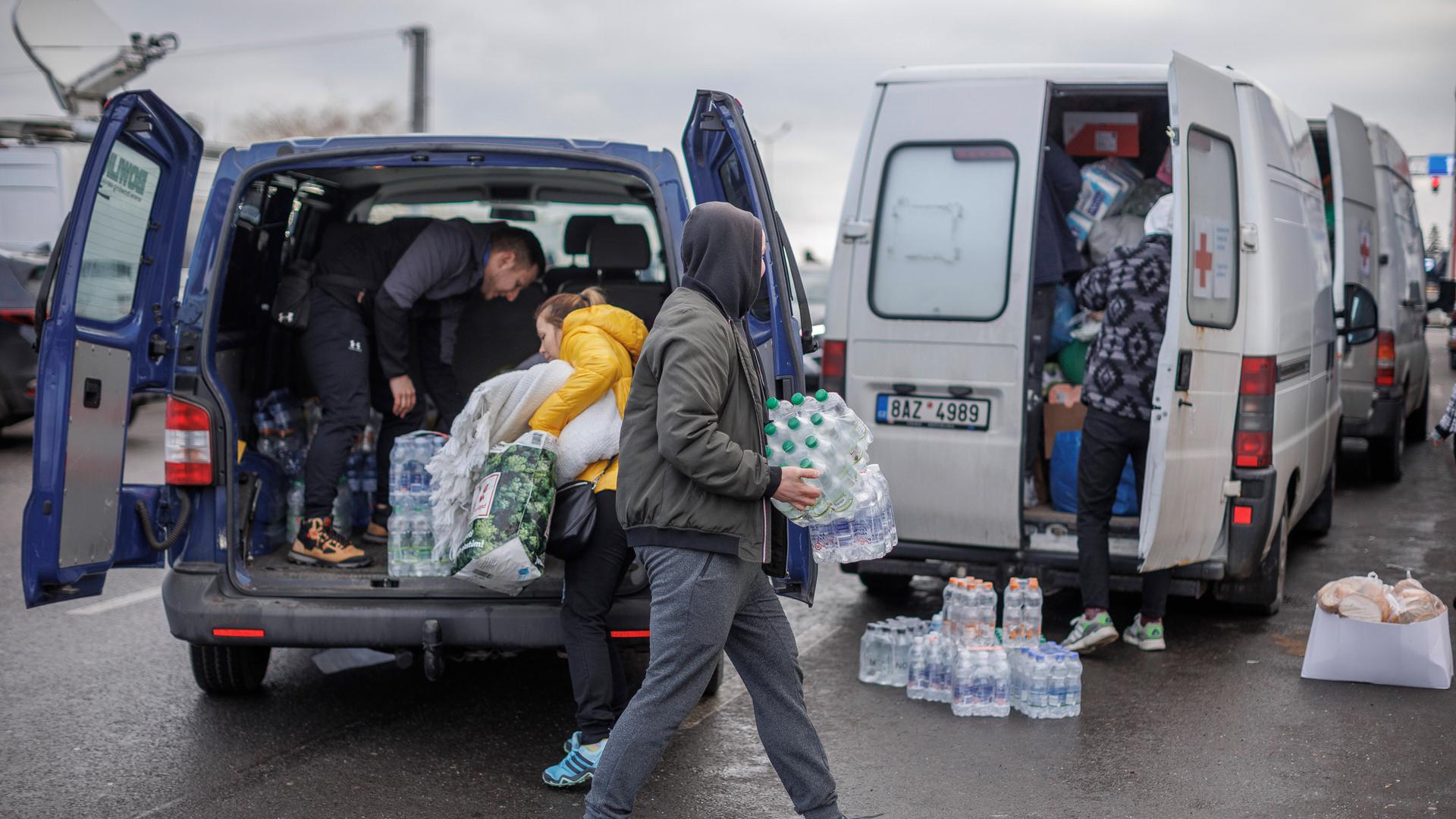 Freiwillige verteilen Wasser an Ukrainische Geflüchtete nach dem Grenzübertritt in Polen. Freiwillige verteilen Wasser an Ukrainische Geflüchtete nach dem Grenzübertritt in Polen.