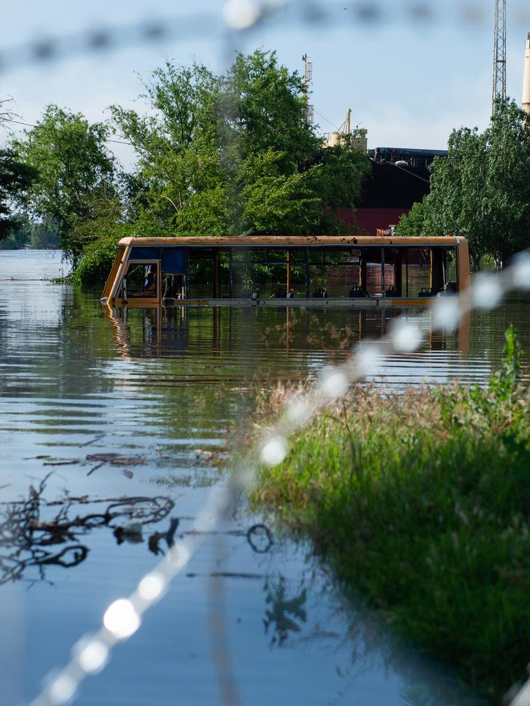 Ein Bus steht bis zur Hälfte überflutet in einer Straße in Cherson.