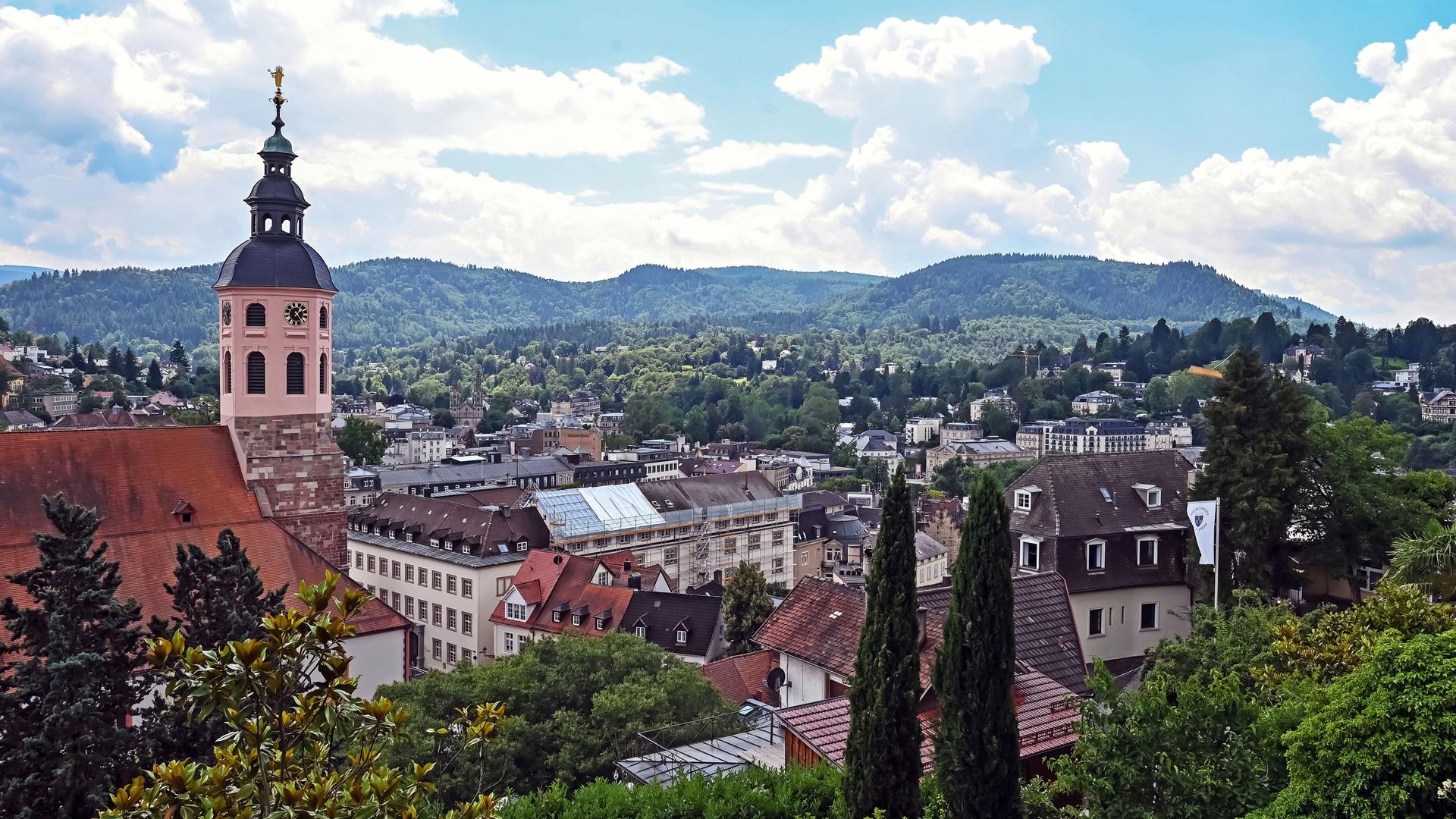 Ein Blick über die Kurstadt Baden-Baden mit grünen Hügeln und Kirchturm.