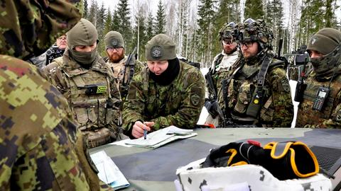 Militärs beugen sich beim NATO-Manöver in Estland im Februar 2022 über Kartenmaterial auf einem Panzer