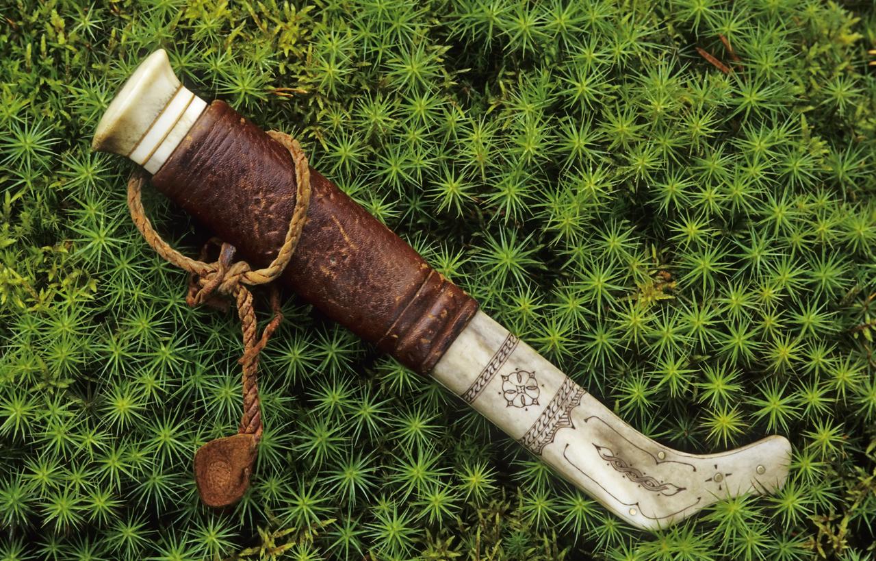 Kunstvoll verziertes samisches Messer im Moos, aus Lappland in Schweden. Kunstvoll verziertes samisches Messer im Moos, aus Lappland in Schweden.