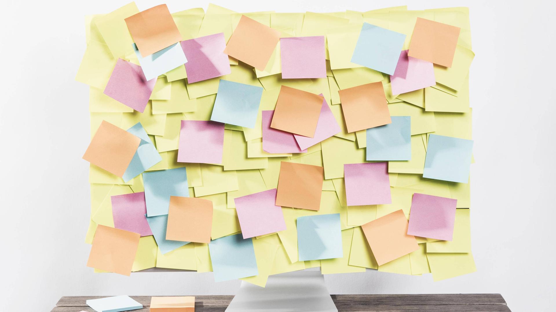 Ein Computerbildschirm ist komplett übersät mit Post-it Zetteln. Ein Computerbildschirm ist komplett übersät mit Post-it Zetteln.