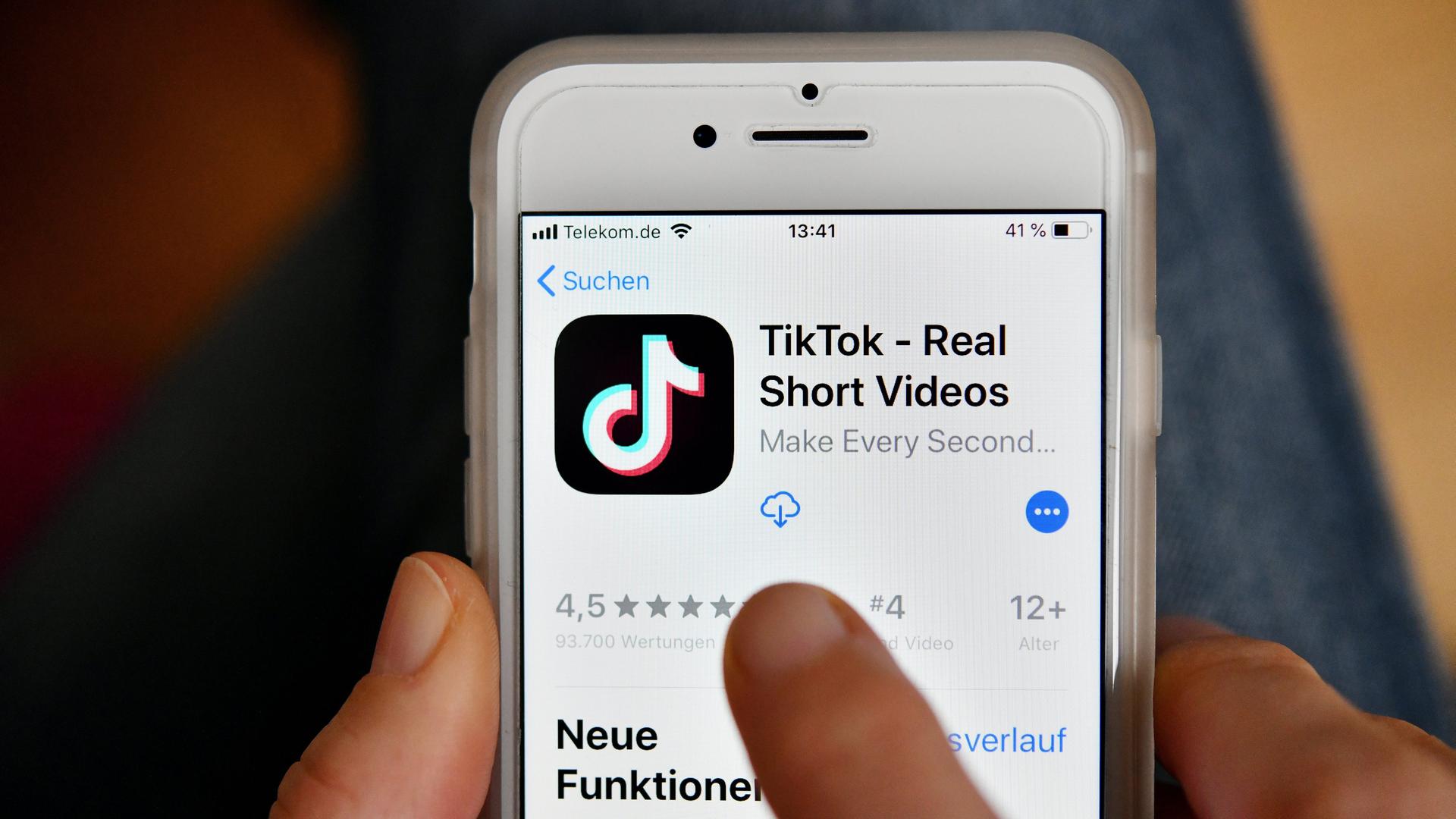 Das Logo der App Tik Tok auf einem Smartphone. Ein Finger tippt auf den Screen.