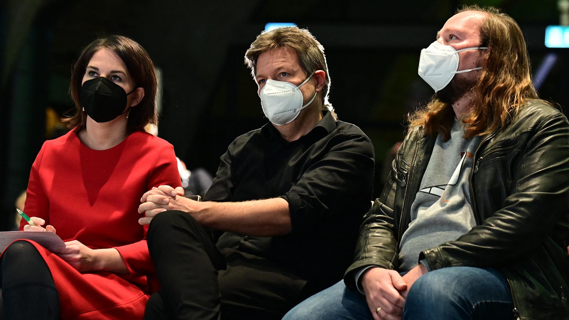 Annalena Baerbock, Robert Habeck und Anton Hofreiter sitzen nebeneinander bei einem Parteitreffen in Berlin.