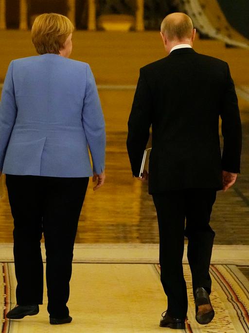 Präsident Putin und Kanzlerin Merkel verlassen eine gemeinsame Pressekonferenz im Kreml.