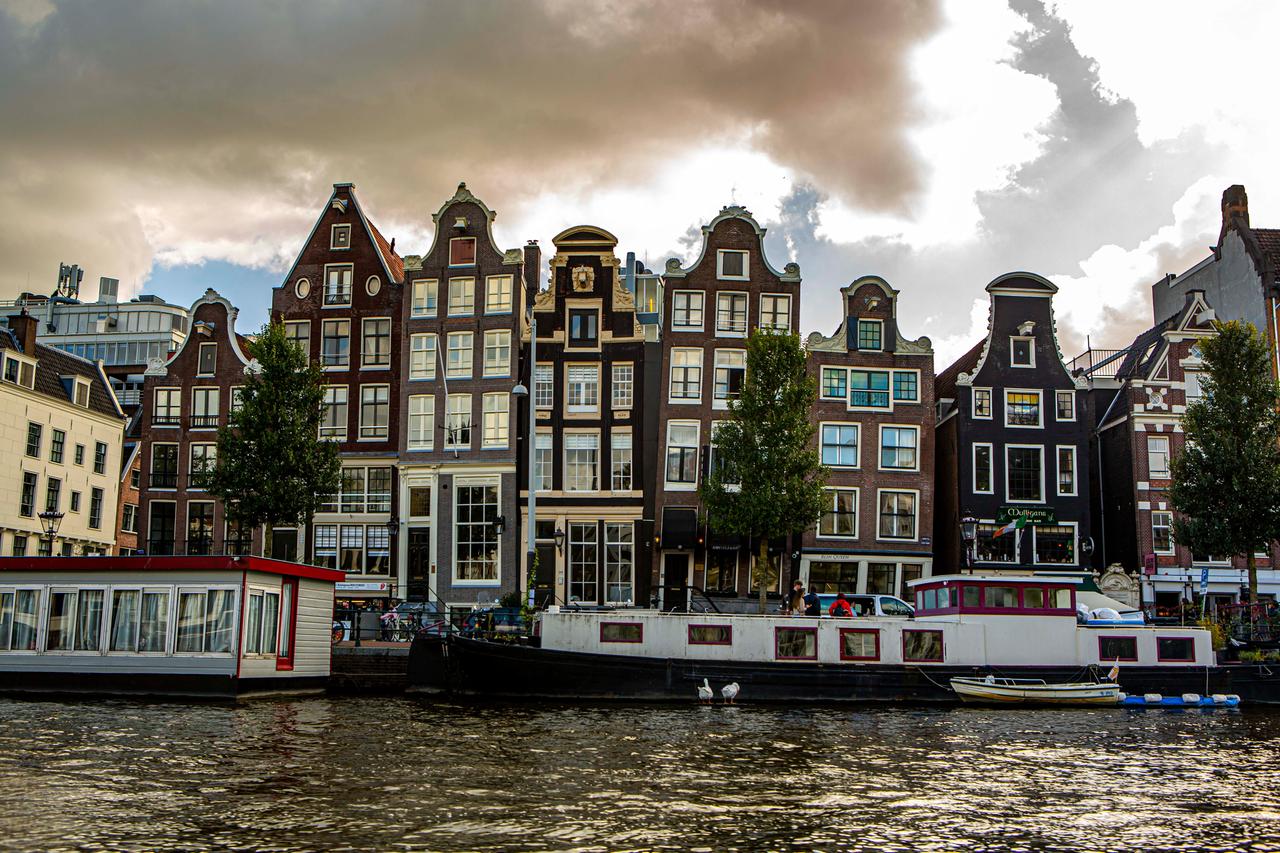 Schiefe Häuser stehen an der Amstel in Amsterdam Schiefe Häuser stehen an der Amstel in Amsterdam