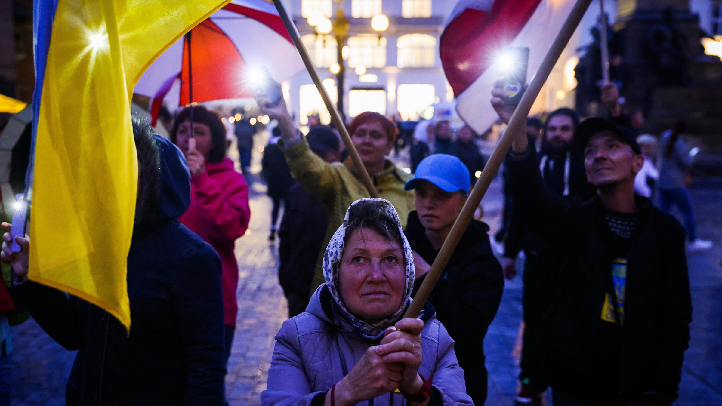 Menschen mit ukrainischen und polnischen Flaggen 