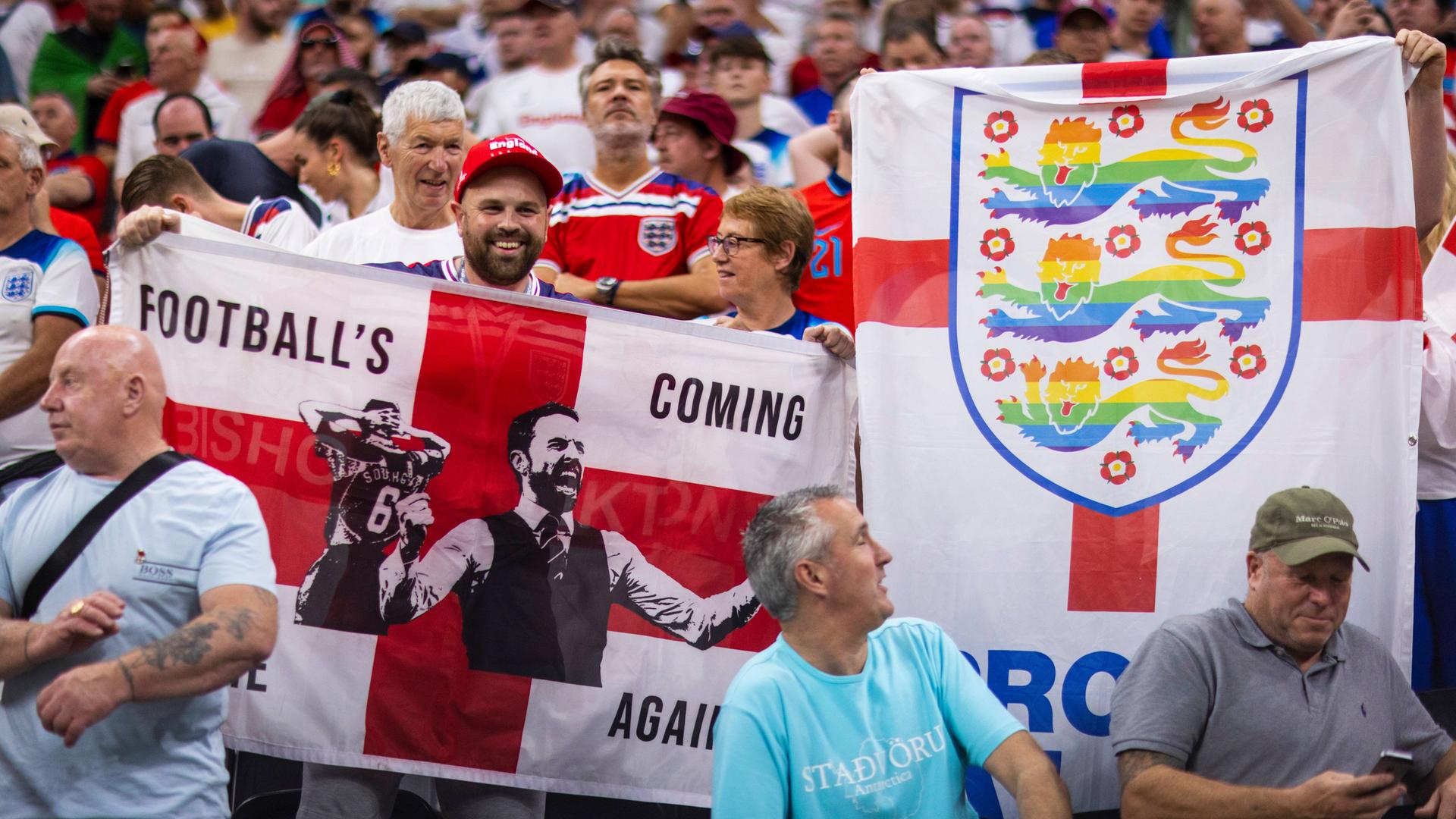 Englische Fans zeigen eine Flagge mit den "Three Lions" in Regenbogenfarben bei der Fußball-WM in Katar. Englische Fans zeigen eine Flagge mit den "Three Lions" in Regenbogenfarben bei der Fußball-WM in Katar.