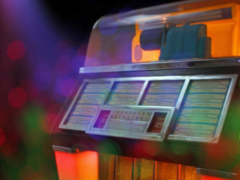 Ihre Glanzzeit hatte die Jukebox in der Mitte des letzten Jahrhunderts. Zu sehen: Eine Jukebox mit unterschiedlichen Farben beleuchtet. 