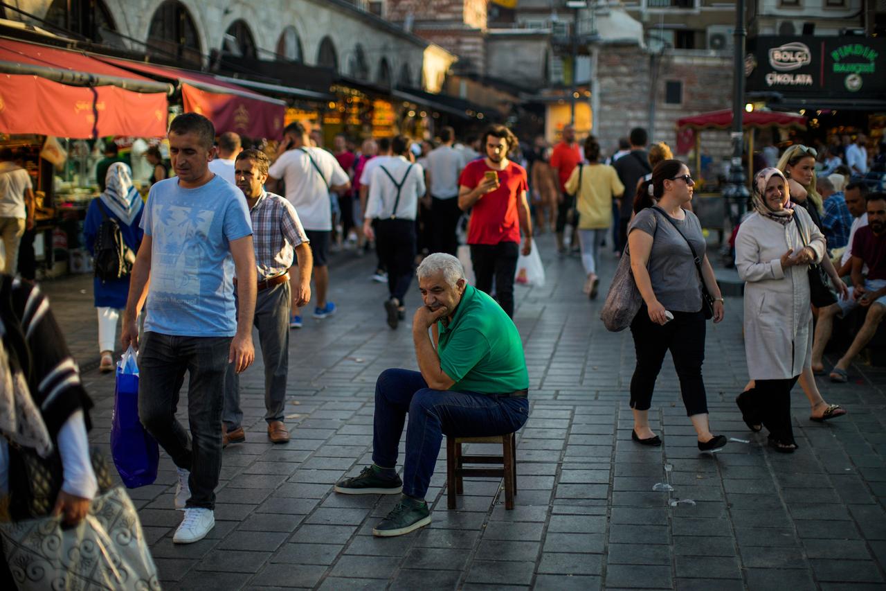 Ein älterer Mann sitzt inmitten einer Straße vor dem Ägyptischen Gewürzmarkt in Istanbul. Ein älterer Mann sitzt inmitten einer Straße vor dem Ägyptischen Gewürzmarkt in Istanbul.
