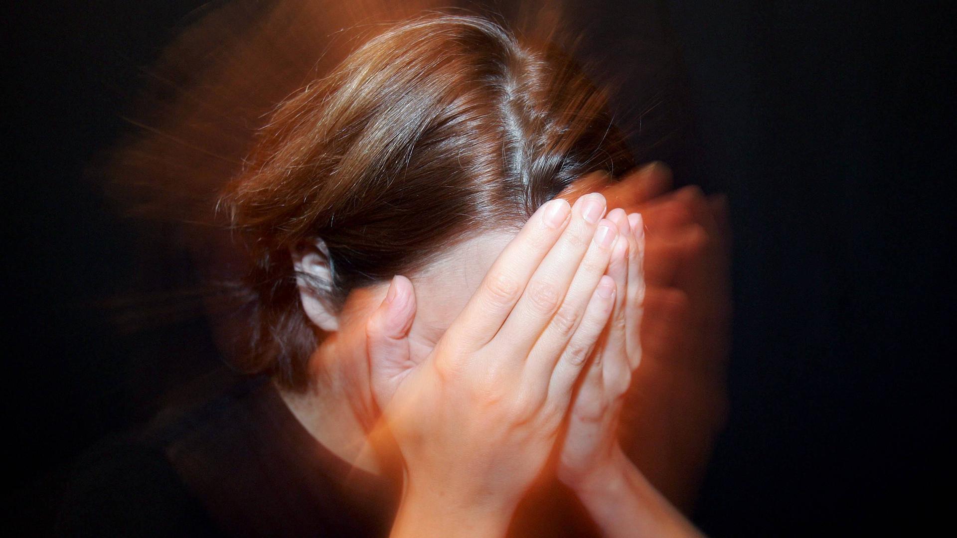 Frau hält sich die Hände vors Gesicht Frau hält sich die Hände vors Gesicht