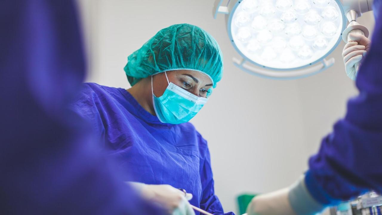 Eine Ärztin in Schutzkleidung bei einer Operation Eine Ärztin in Schutzkleidung bei einer Operation
