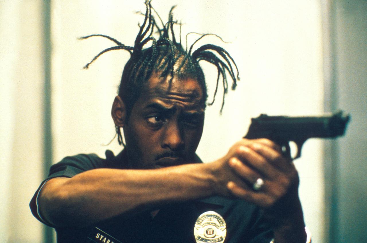 Polizei-Officer Starkey, verkörpert vom US-amerikanischen Rapstar Coolio, macht im Kinofilm "The Convent" von seiner Schusswaffe Gebrauch (Szenenfoto). Polizei-Officer Starkey, verkörpert vom US-amerikanischen Rapstar Coolio, macht im Kinofilm "The Convent" von seiner Schusswaffe Gebrauch (Szenenfoto).