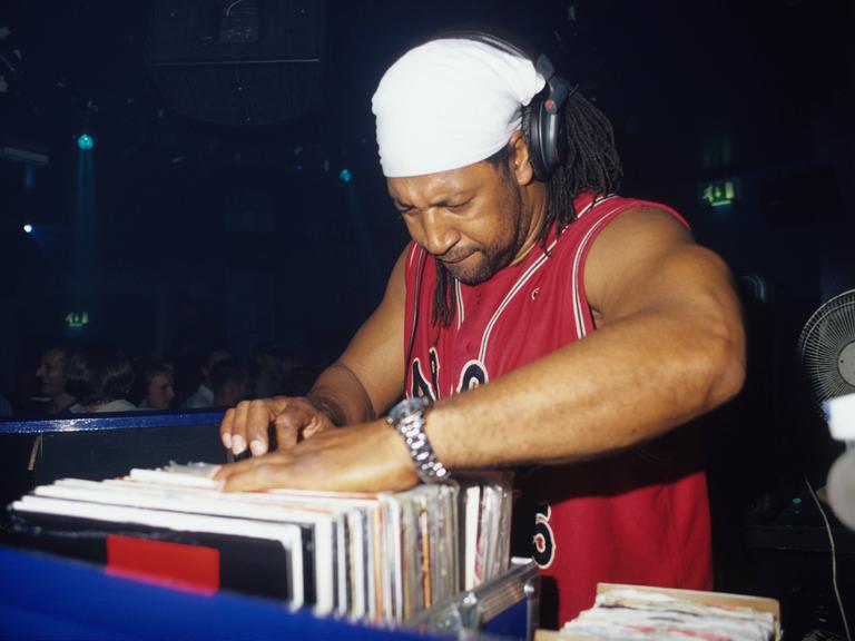 DJ Kool Herc durchsucht seine Platten bei einem Auftritt.
