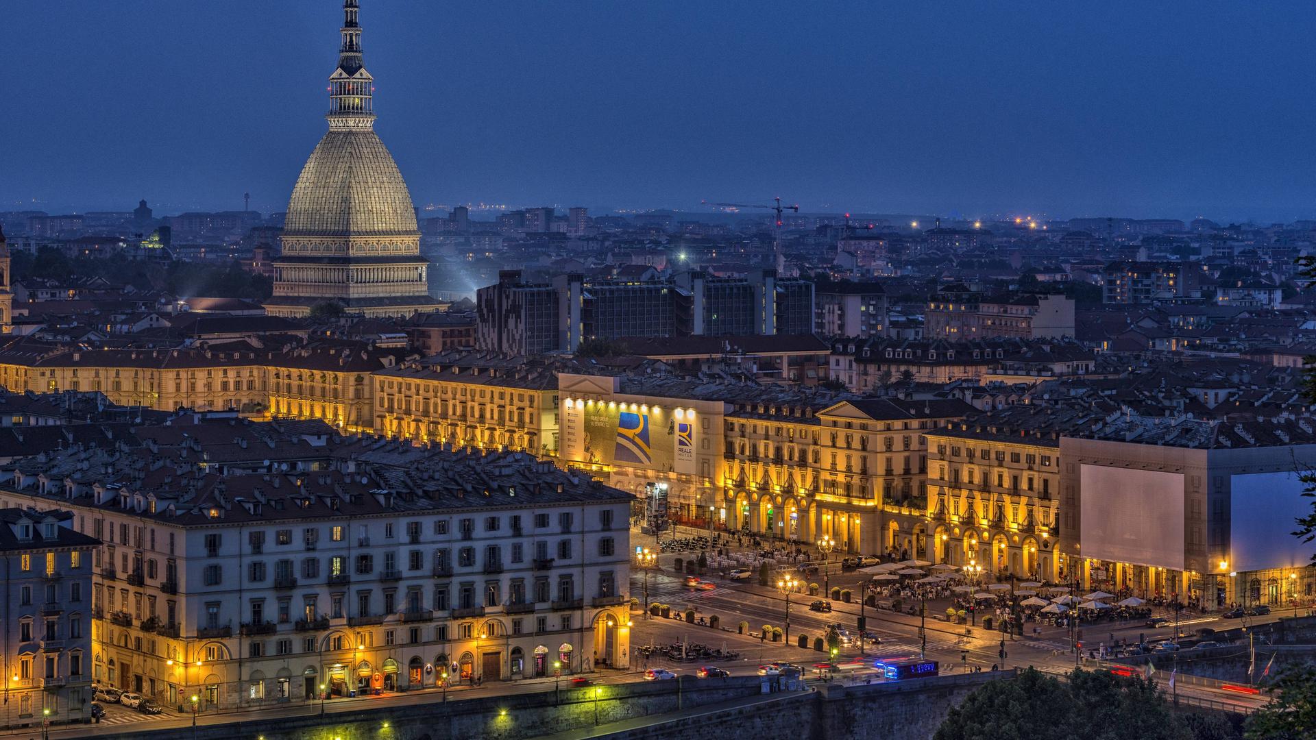 Die erleuchtete Stadt Turin bei Nacht, über der die Mole Antonelliana thront. Der pavillonartige Bau mit seinem hohen, sich stark verjüngenden Aufsatz ist das Wahrzeichen der Stadt. Die erleuchtete Stadt Turin bei Nacht, über der die Mole Antonelliana thront. Der pavillonartige Bau mit seinem hohen, sich stark verjüngenden Aufsatz ist das Wahrzeichen der Stadt.