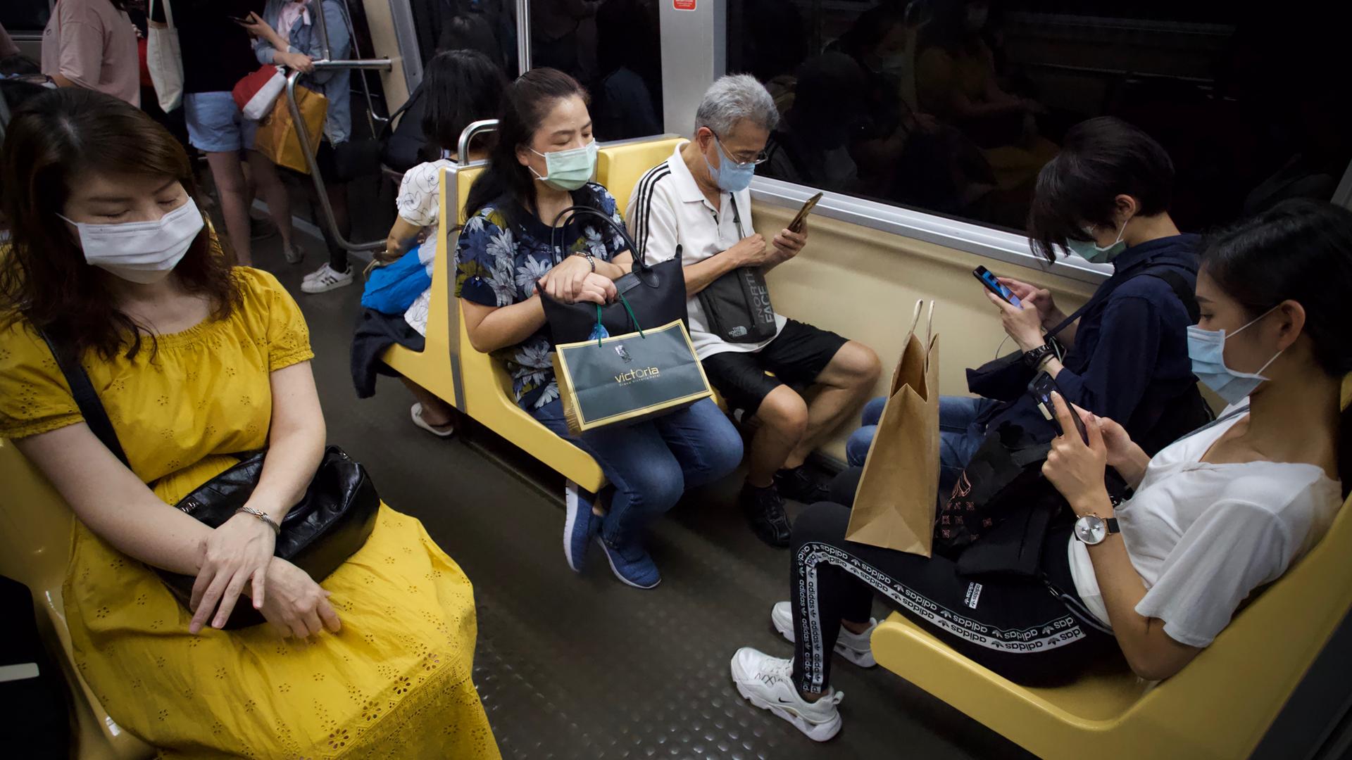Fahrgäste in der U-Bahn von Taipeh. Die meisten tragen Masken und schauen auf ihre Smartphones. Fahrgäste in der U-Bahn von Taipeh. Die meisten tragen Masken und schauen auf ihre Smartphones.