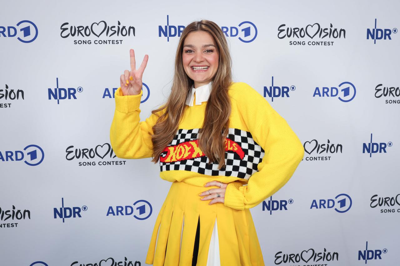 Emily Roberts trägt ein knallgelbes Kleid und lächelt in die Kamera. Emily Roberts trägt ein knallgelbes Kleid und lächelt in die Kamera.